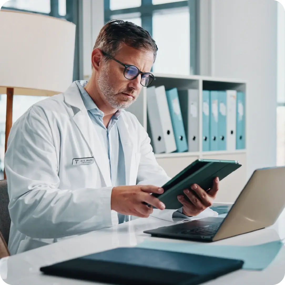 Doctor using laptop and tablet iPad_POPIA-compliant data management_Altron HealthTech